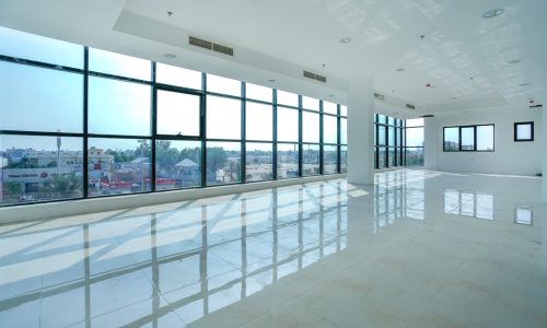 Semi furnished office space in a luxurious building with expansive windows offering city views.