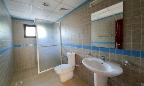 A blue-tiled bathroom with a toilet in a wonderful 3BR Villa with Garden in Saar.