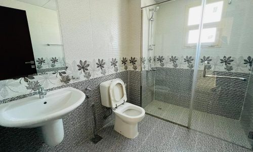 A modern bathroom with a sink and shower.