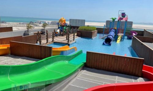 An apartment with a sea view and colorful slides next to a beach