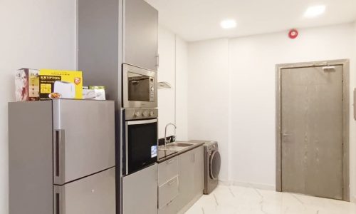 A small kitchenette furnished with a refrigerator and microwave.