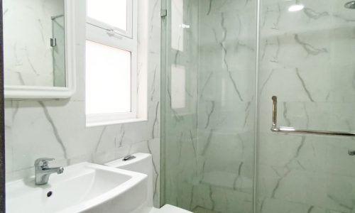 An elegant bathroom with a glass shower stall.