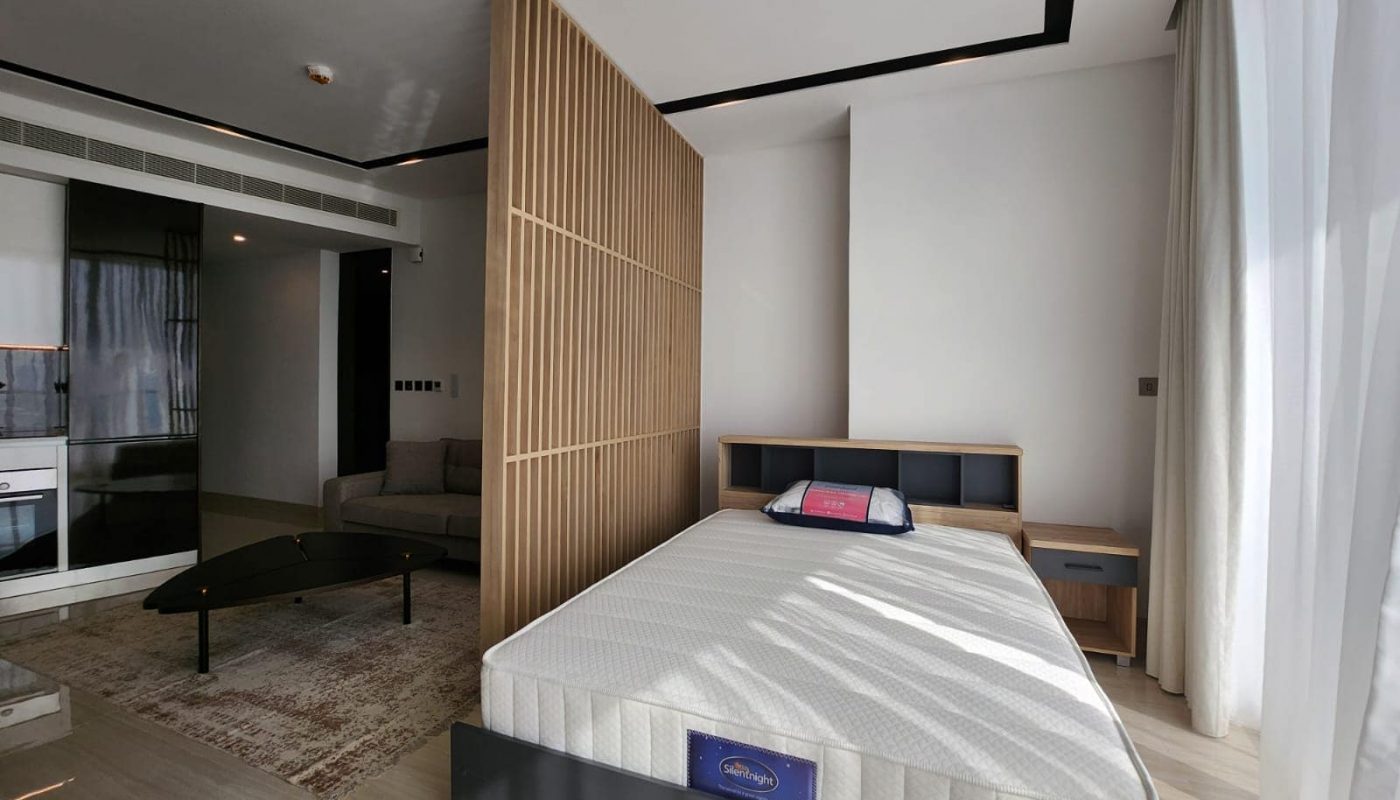 A studio bedroom in Spiral Orchid Residence, featuring a bed and a bedside table.