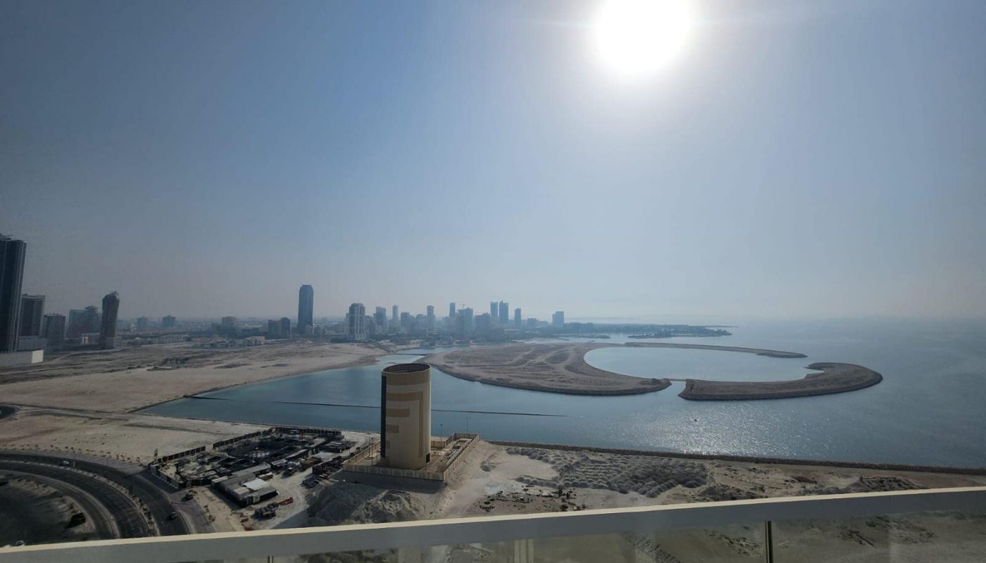 A city next to water, featuring the Spiral Orchid Residence Studios, a prime piece of real estate.