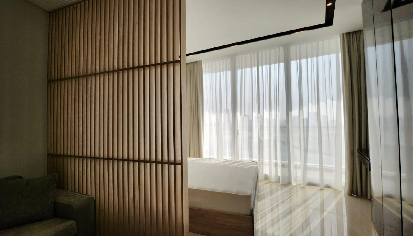 A studio in Spiral Orchid Residence with a wooden wall and a bed.