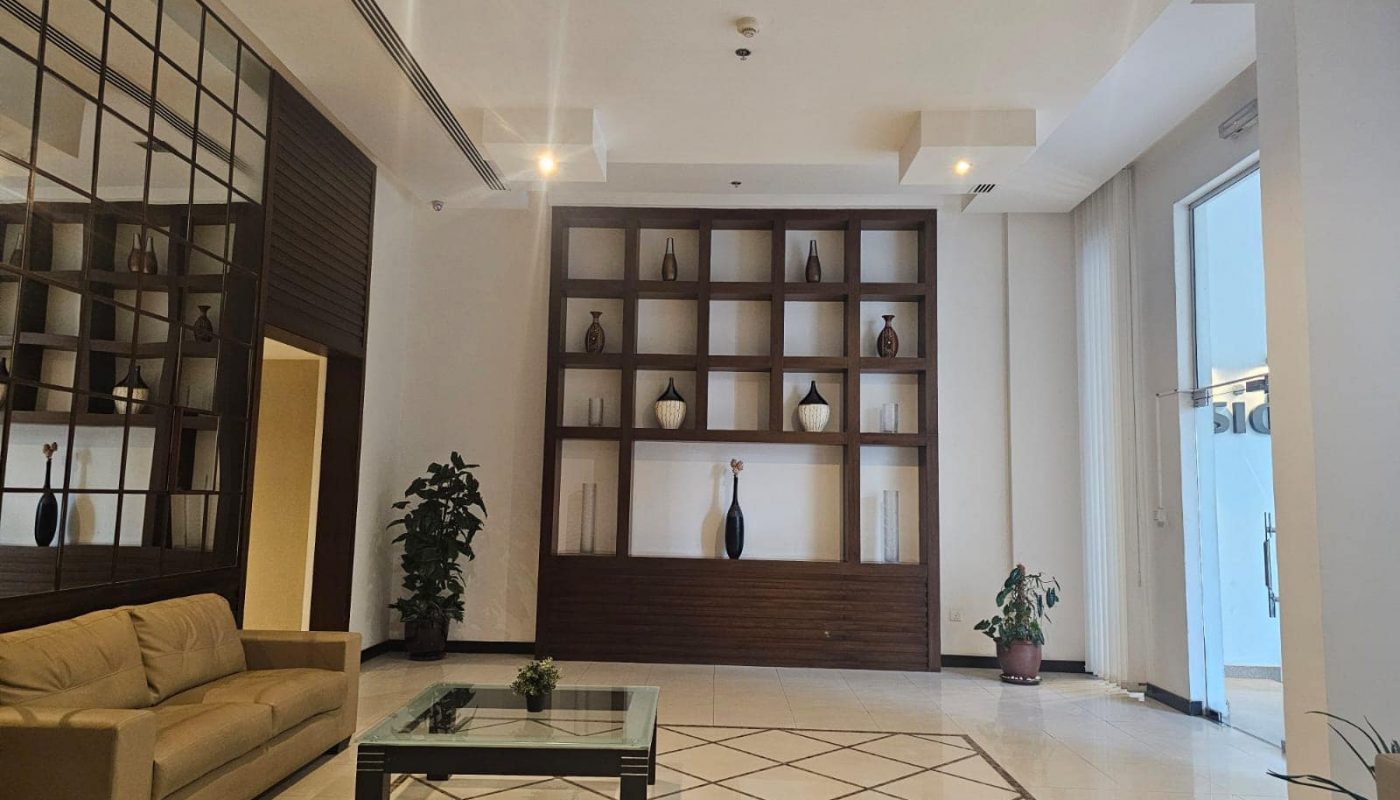 A flat lobby with a coffee table and a glass wall available for rent in Juffair.