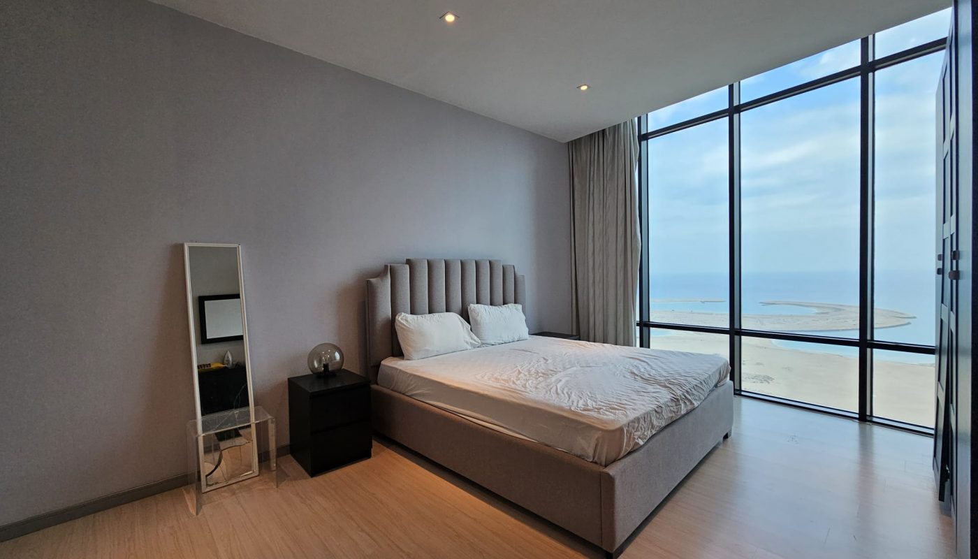 A flat for rent in the Seef area with large windows overlooking the ocean.