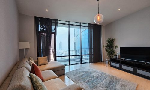 A rental flat in the Seef area featuring a living room with a flat screen TV and a stunning view of the city.