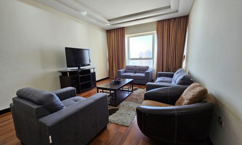 A spacious living room with comfortable couches and a modern TV in a rented Sanabis flat.