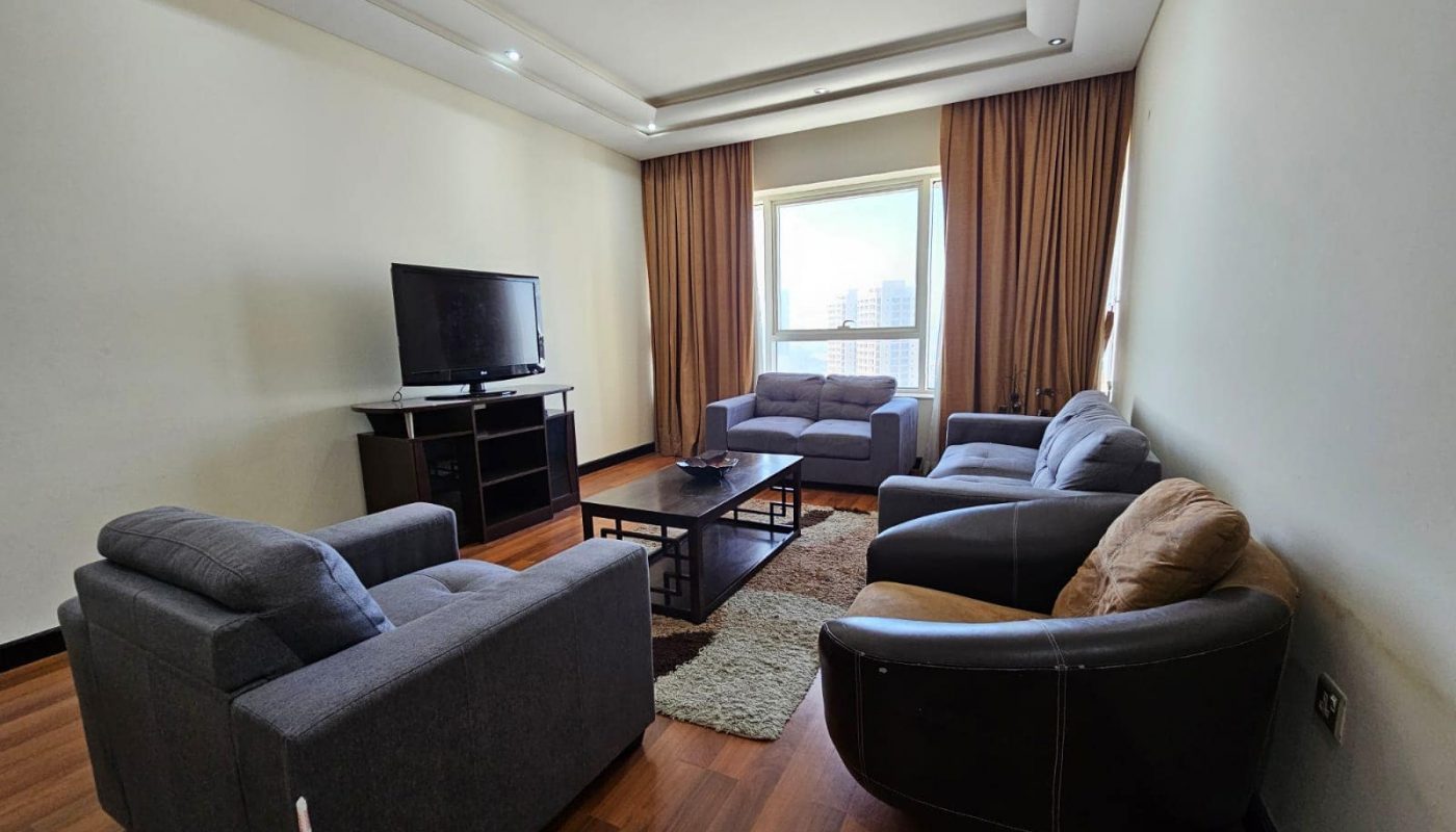 A spacious living room with comfortable couches and a modern TV in a rented Sanabis flat.