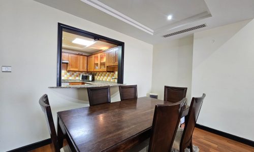 A flat in Sanabis available for rent, featuring a dining room with a wooden table and chairs.