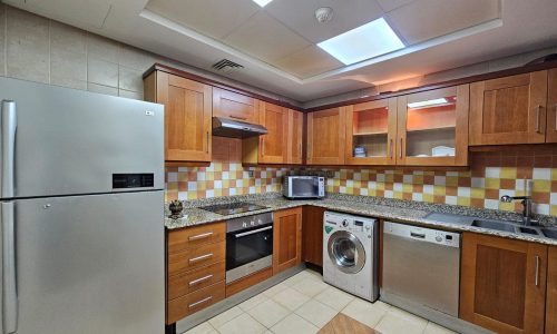 A flat with stainless steel appliances and wooden cabinets available for rent in Sanabis.