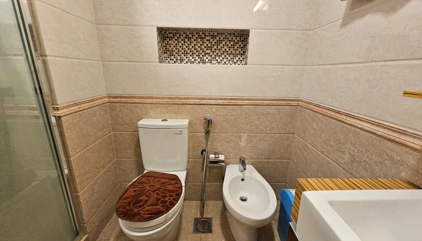 A bathroom with a toilet and a shower.