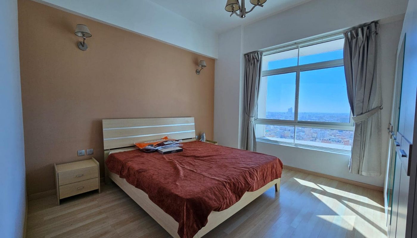 A bedroom with a bed and a window.