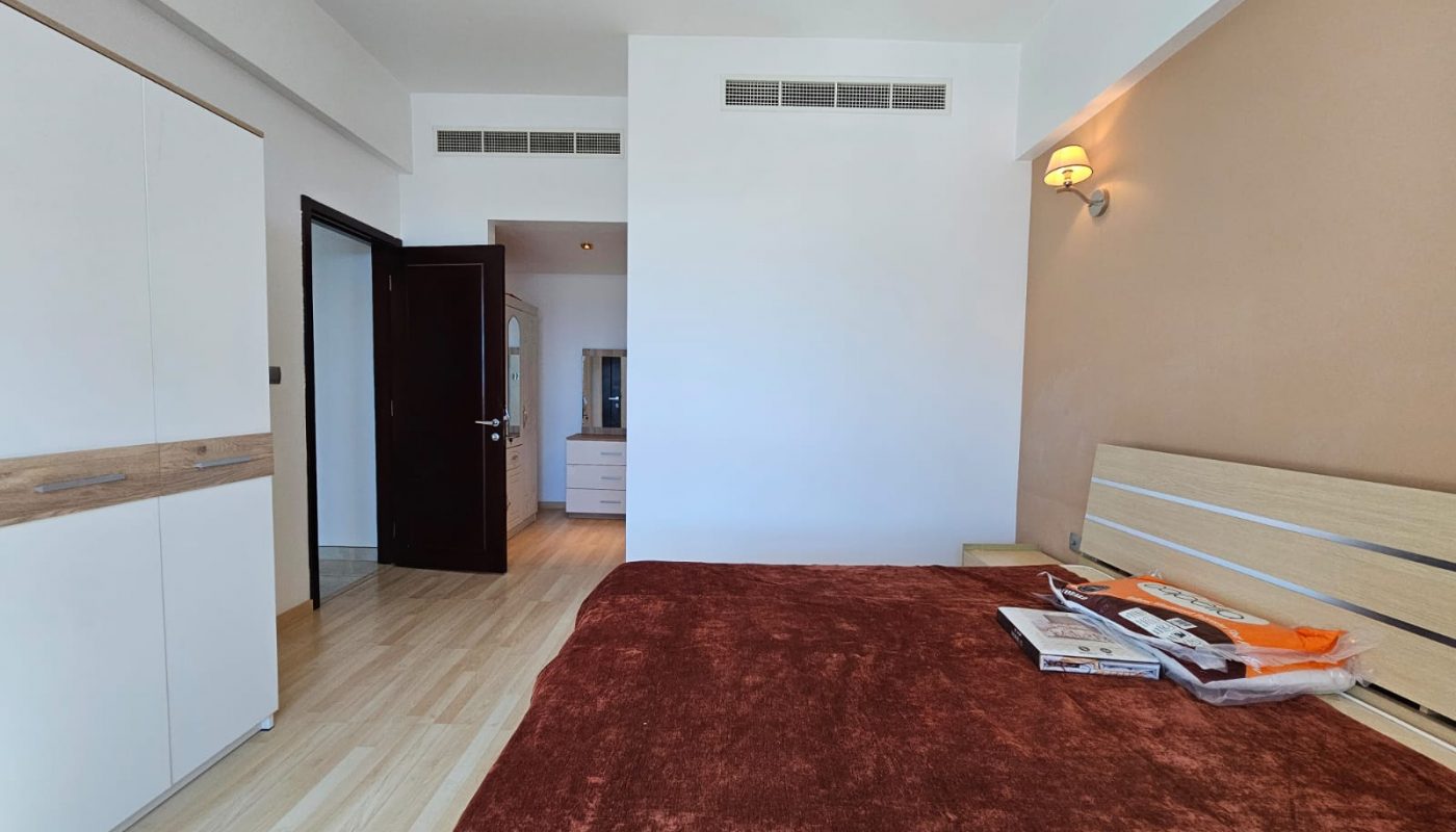 A bedroom with a bed and a dresser.