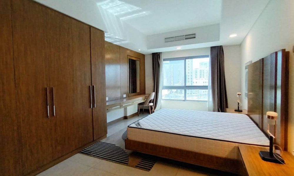 A bedroom with wooden cabinets and a bed.