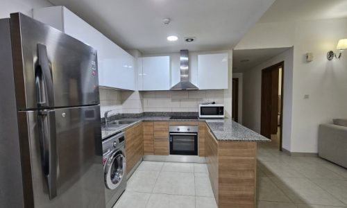 A kitchen in a Juffair flat for rent with a stainless steel refrigerator and oven.