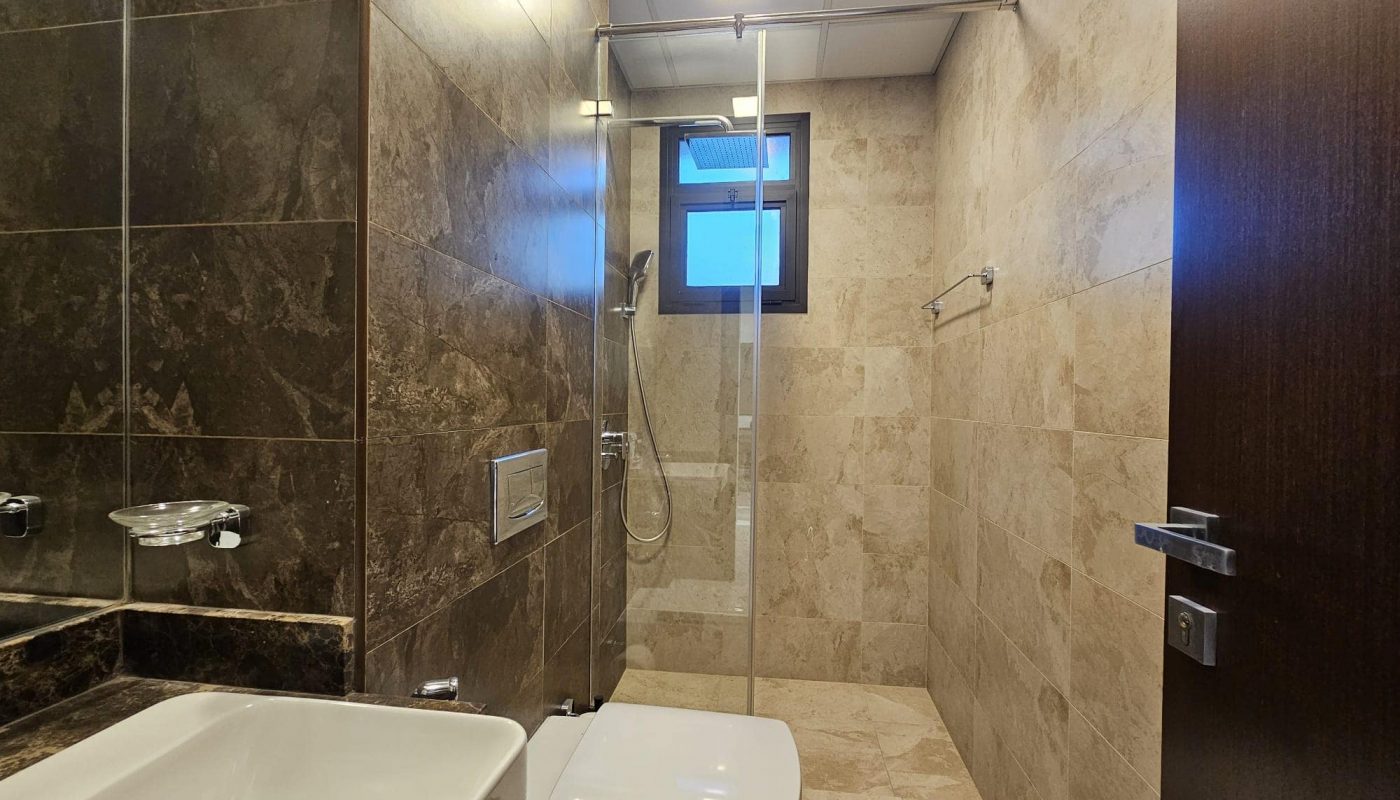 A bathroom with a toilet and shower.