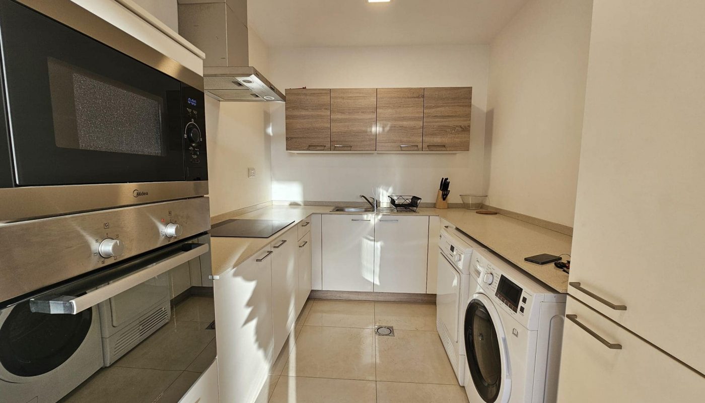 A compact kitchen with a washer and dryer.