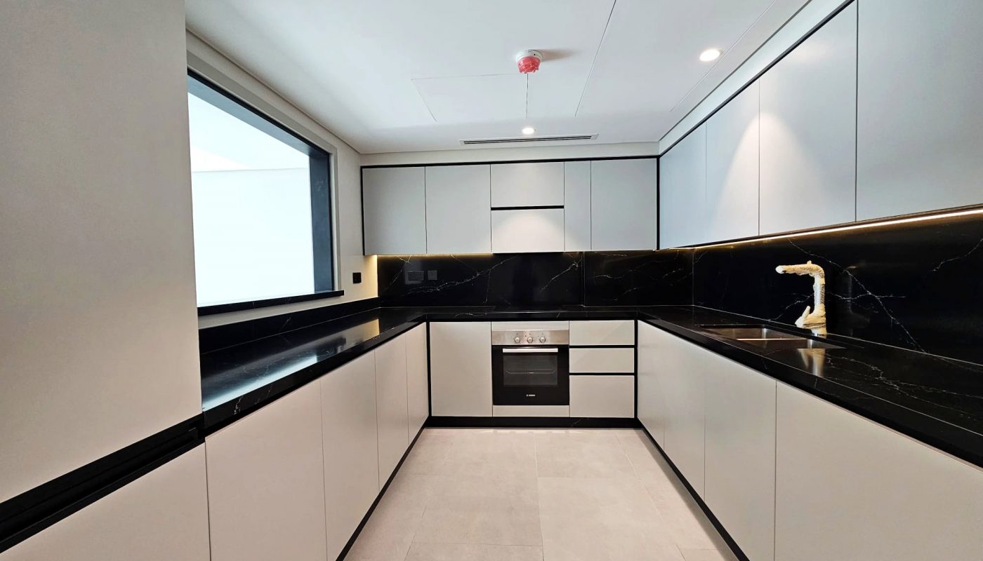 Modern kitchen with black countertops, built-in appliances, and white cabinetry. Auto Draft