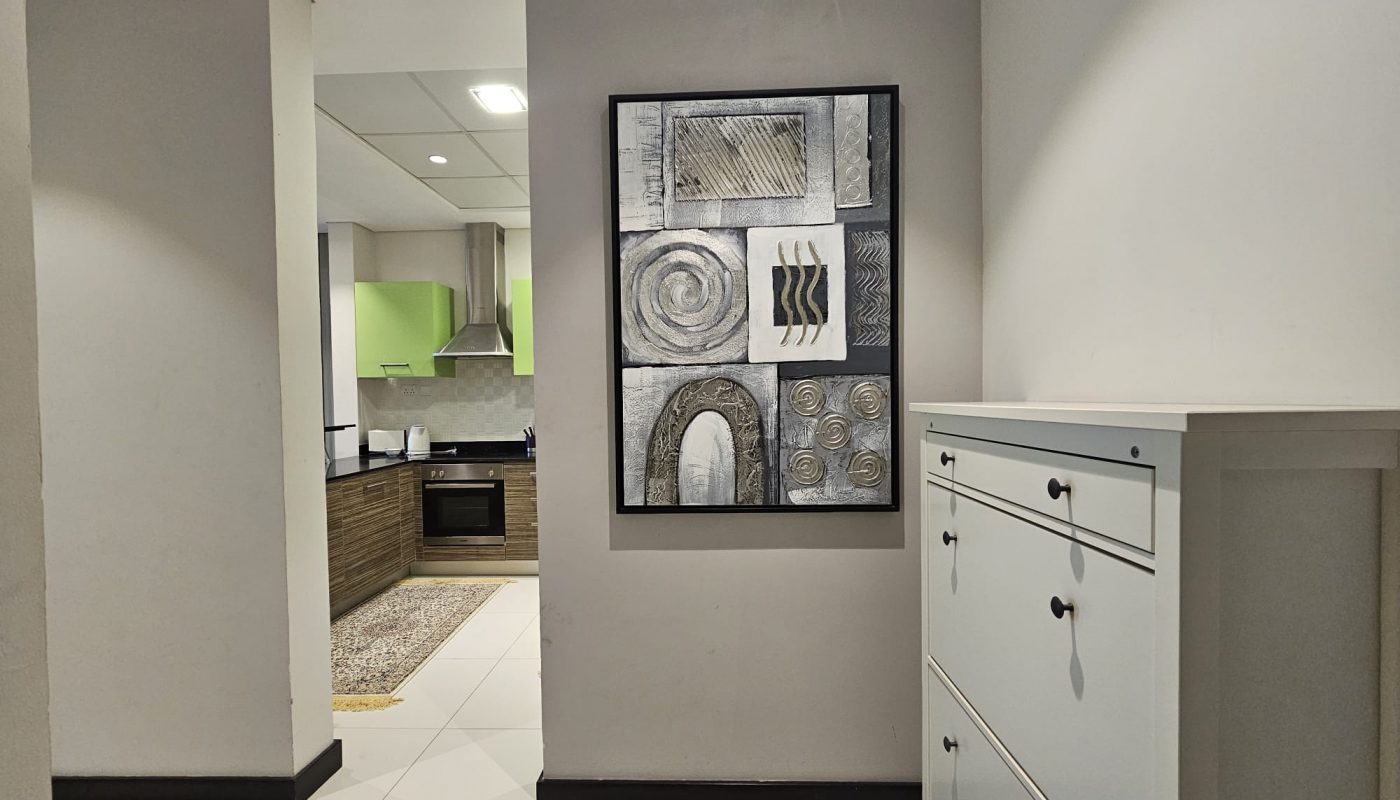 Modern kitchen seen through a doorway with an Auto Draft on the adjacent wall in a clean, contemporary interior.