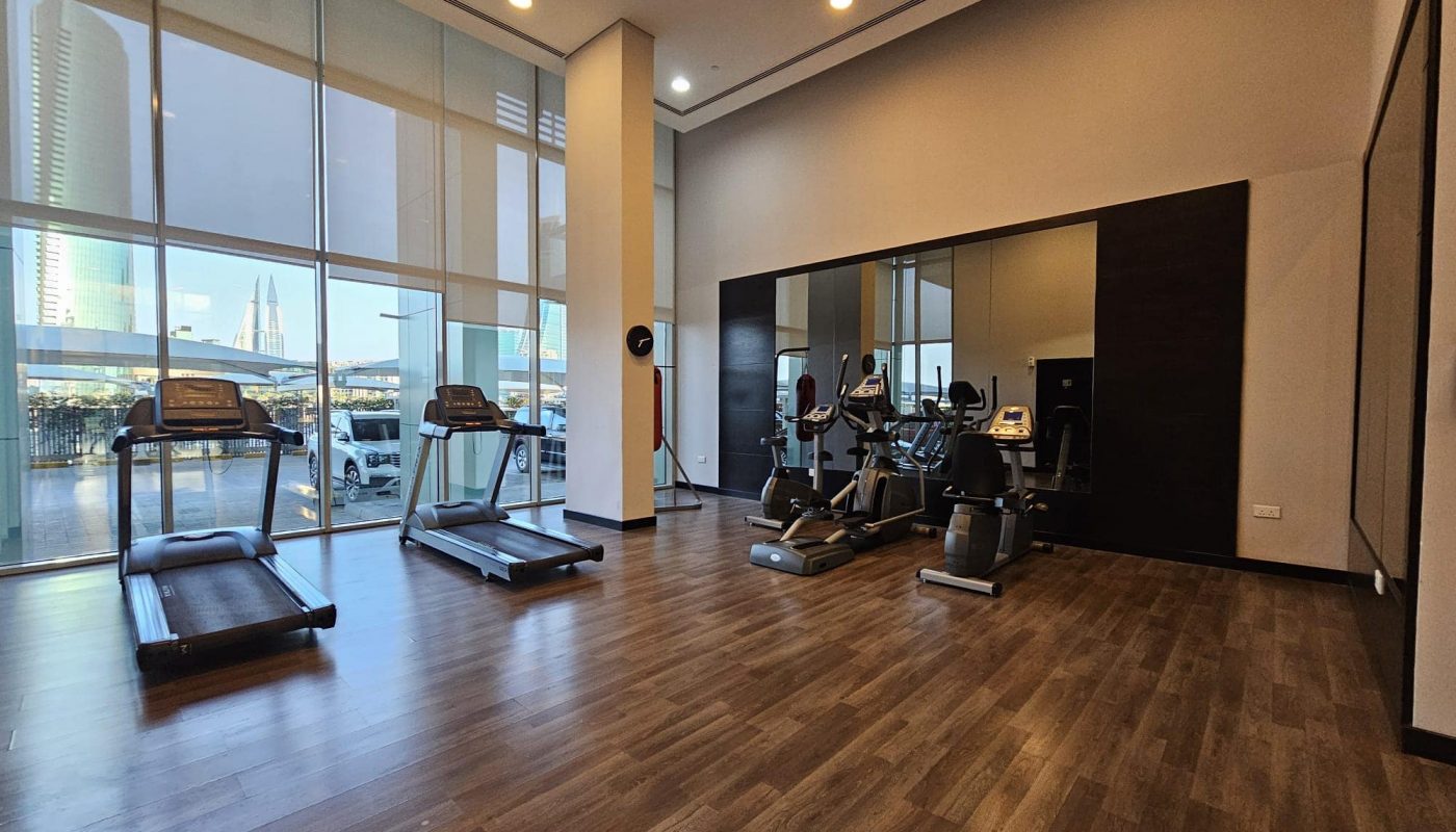 Modern gym with cardio machines overlooking a cityscape through large windows, upgraded to include Auto Draft systems.