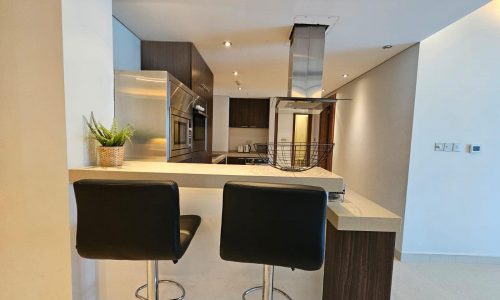 Modern kitchen interior with a breakfast bar and two stools.