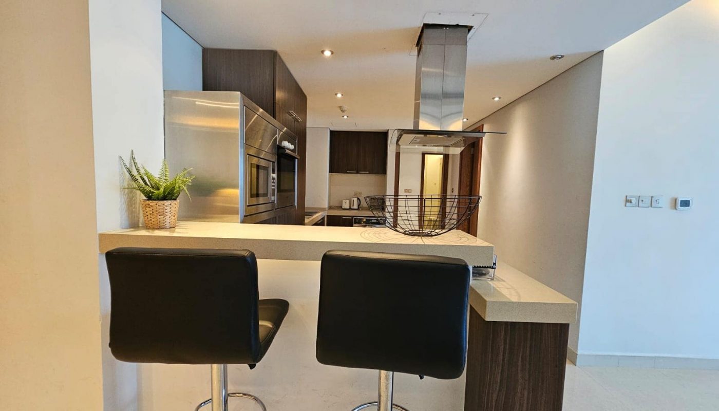 Modern kitchen interior with a breakfast bar and two stools.