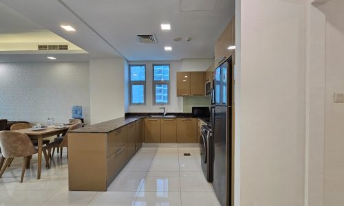 Modern kitchen with wooden cabinets, stainless steel appliances, and an adjoining dining area - Auto Draft.