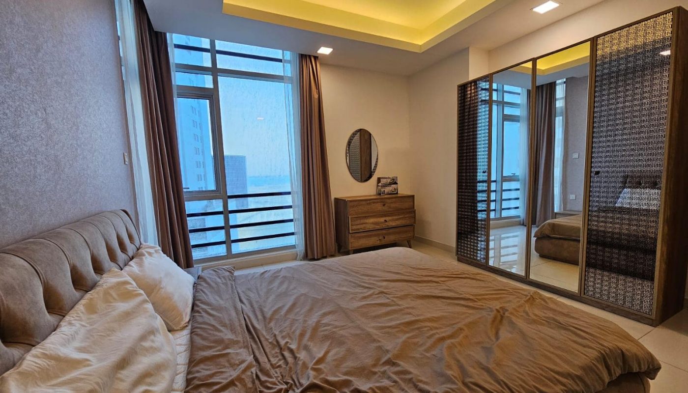 A modern bedroom with a large bed, ambient lighting, and access to an en-suite bathroom. Auto Draft