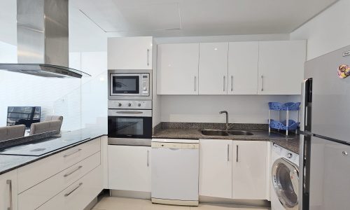 A modern concept kitchen with white cabinets, stainless steel appliances, and granite countertops.