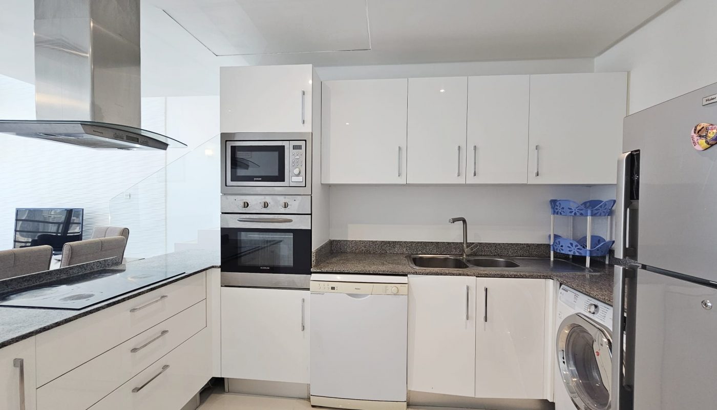 A modern concept kitchen with white cabinets, stainless steel appliances, and granite countertops.