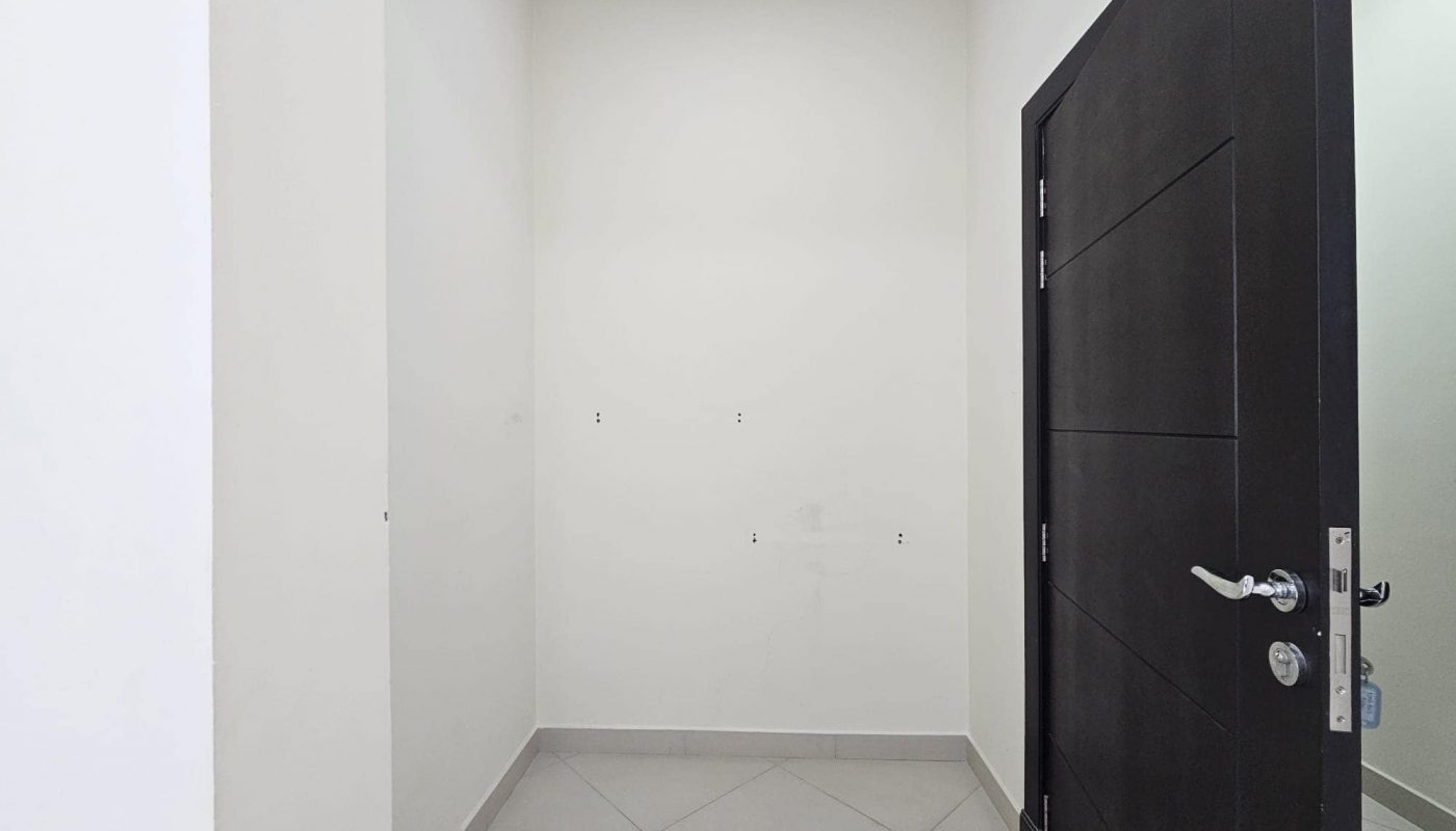 An empty white 2BR room with an open black door and tile flooring.