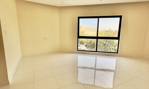 A luxurious, bright 4 Bedrooms Villa in Saraya 1 with white tiled flooring and a large window offering a view of greenery outside.