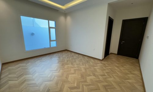 A room with a wood floor and a window overlooking the Villa.