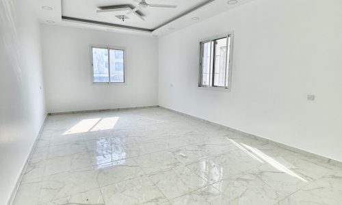 A luxurious apartment in Al Bahair, adorned with marble floors and equipped with a ceiling fan.