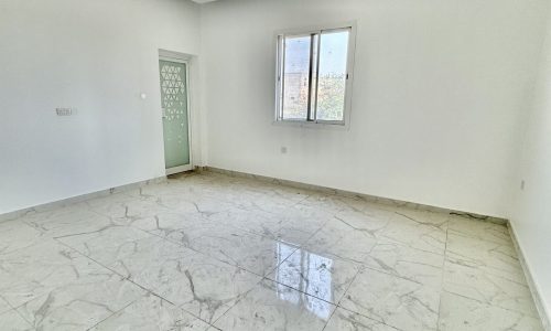 A luxurious Al Bahair apartment with marble floors and a ceiling fan, available for sale.