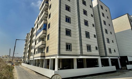 A luxury apartment building with a street sign for sale.