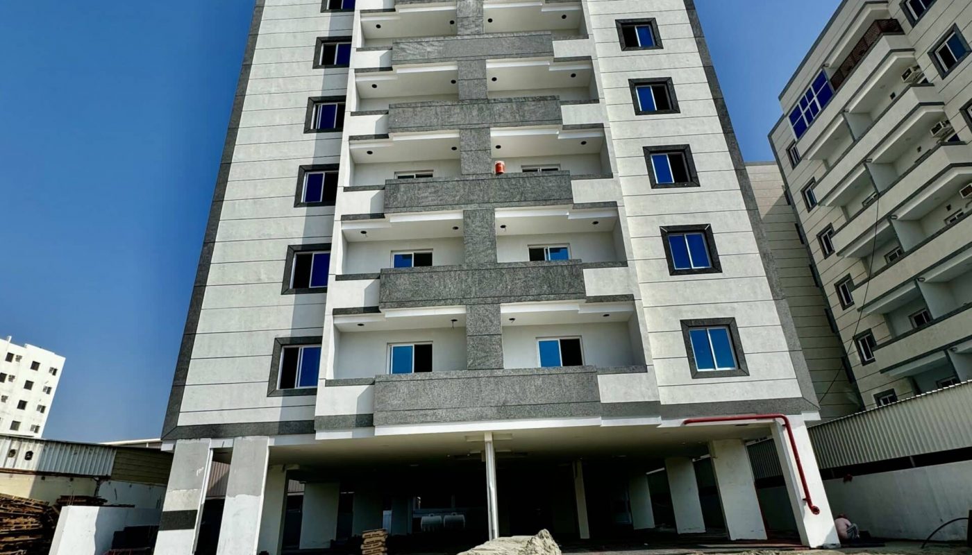 A luxury apartment building under construction with dirt and sand.