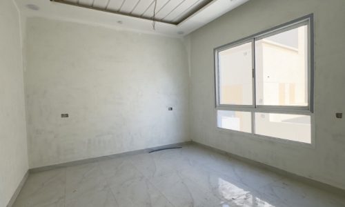 An elegant empty room with white walls and tile floors.