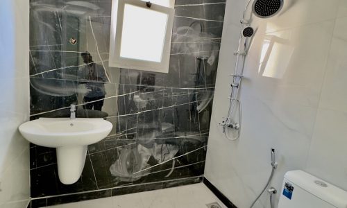 An elegant black and white bathroom adorned with a toilet and sink.