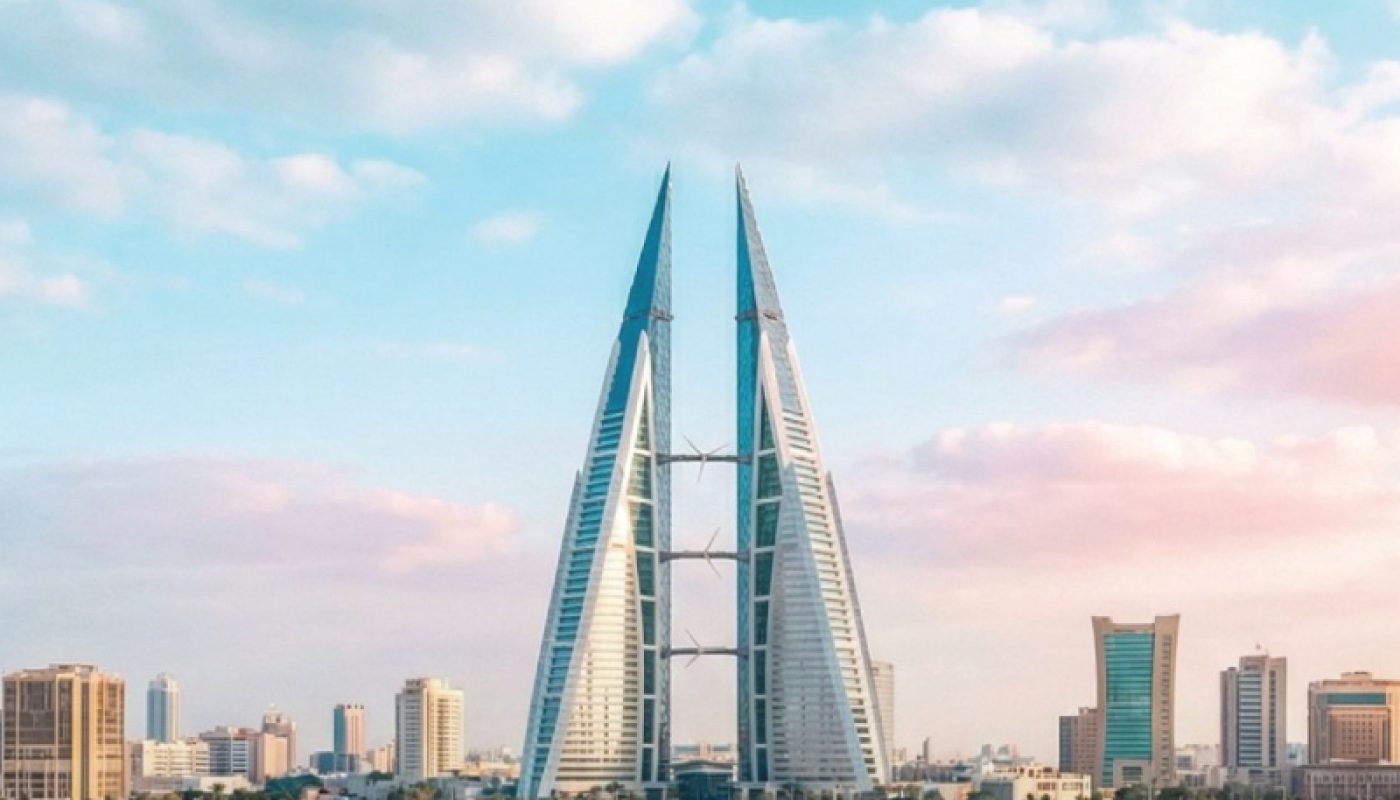 A pair of modern, sail-shaped skyscrapers stand by the water in a cityscape, with other high-rise buildings and a partly cloudy sky in the background.