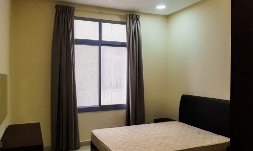 A furnished bedroom with a bed and a window in a 2BR apartment for rent in Adliya.