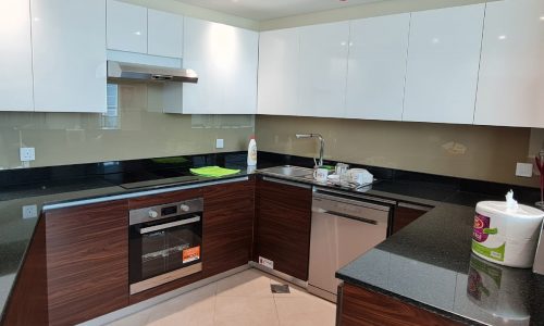 A modern kitchen with stainless steel appliances and black counter tops.