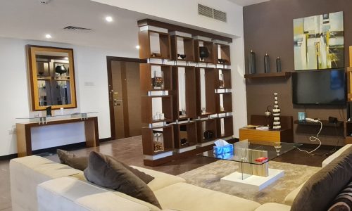 An exquisite apartment in Juffair featuring a living room with couches and a flat screen TV.