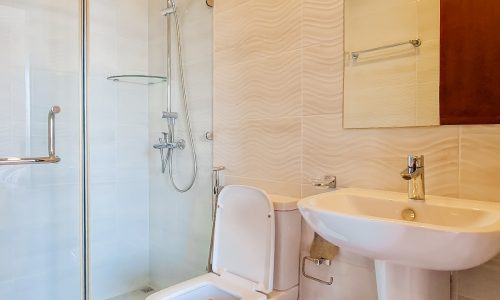 A luxury bathroom with a toilet, sink and shower in a 1BHK Apartment for Sale in Juffair.