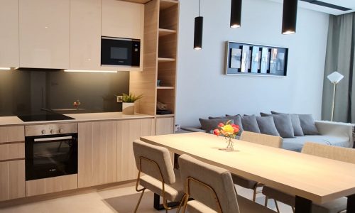 A kitchen and dining area in a fully furnished modern apartment.