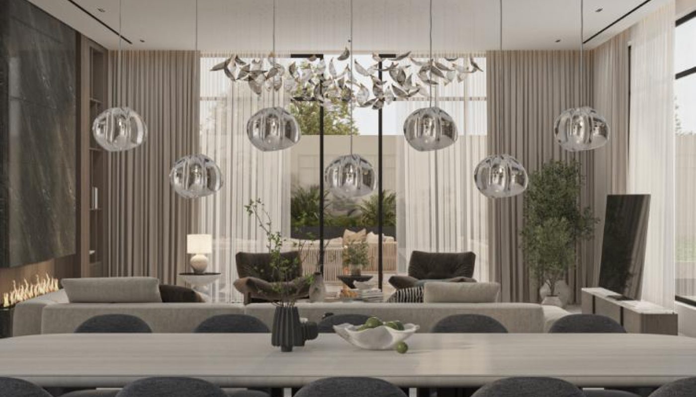 Modern living and dining room with gray upholstered chairs, a long table, glass pendant lights, large windows, sheer curtains, and neutral decor.