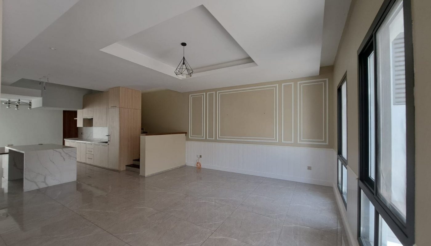 A luxurious Saraya 1 villa with exceptional design showcasing an empty kitchen and living room adorned with pristine marble floors.