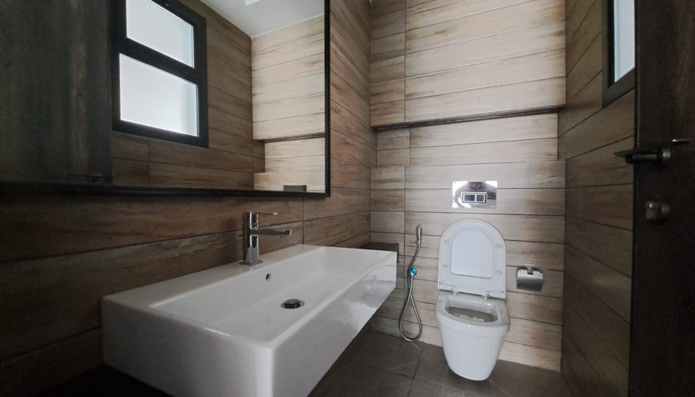A luxurious bathroom with wooden walls and a toilet, located in Saraya 1, available for sale.